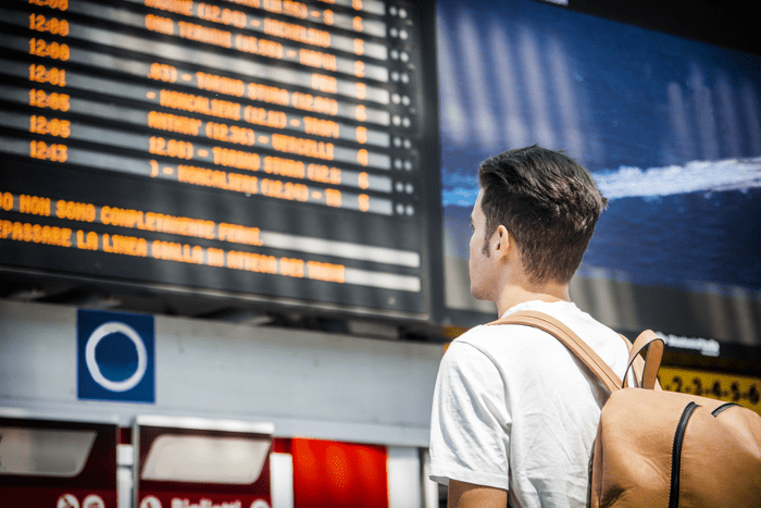 Man looking at a digital timetable for public transportation