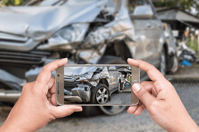 Thanks to AI-enabled claims processes and prompts from an AI chatbot, an insured takes a photo of damage to their car after a crash so the insurers system can set off a FNOL.